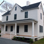 A symmetrical front elevation and wide porch reflect traditional ways of building.