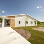 Side elevation.  Where people come in contact with the building, the material is wood shingles.